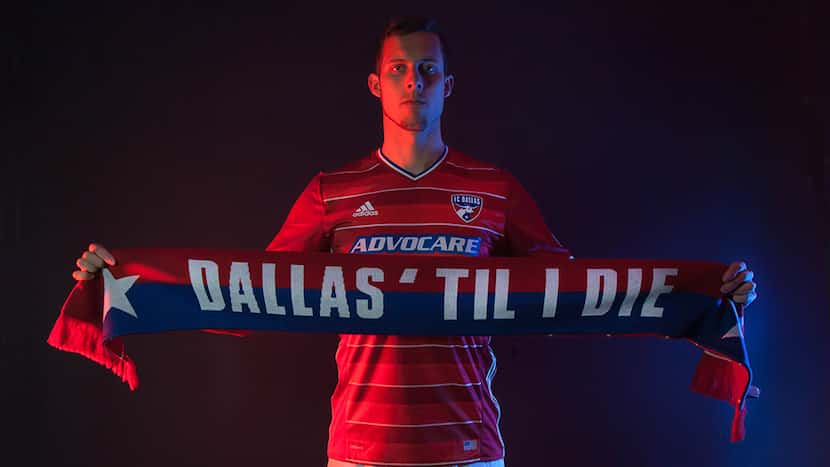 Matt Hedges holds up a scarf with the local fan slogan, Dallas 'Til I Die.