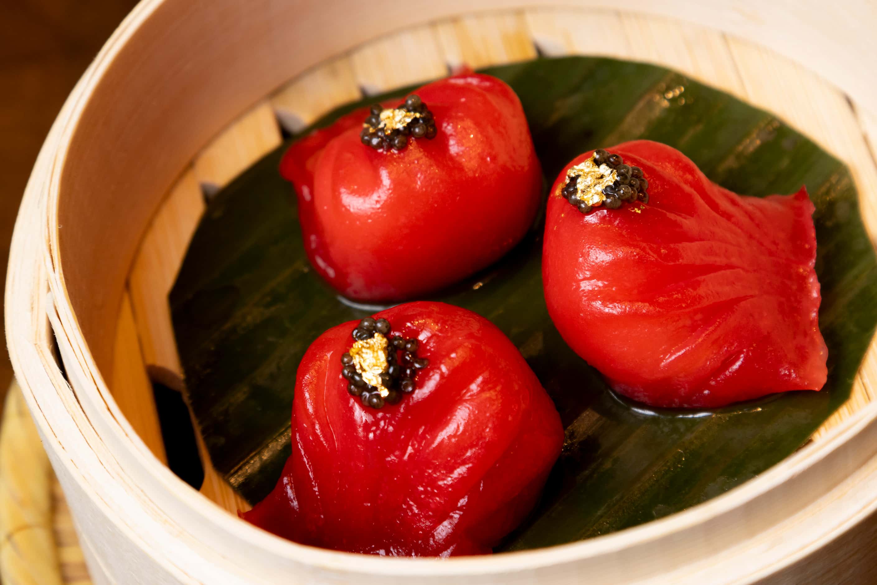 The King Prawn Dumplings, or Har Gow, are prepared with black caviar and gold leaf on top at...