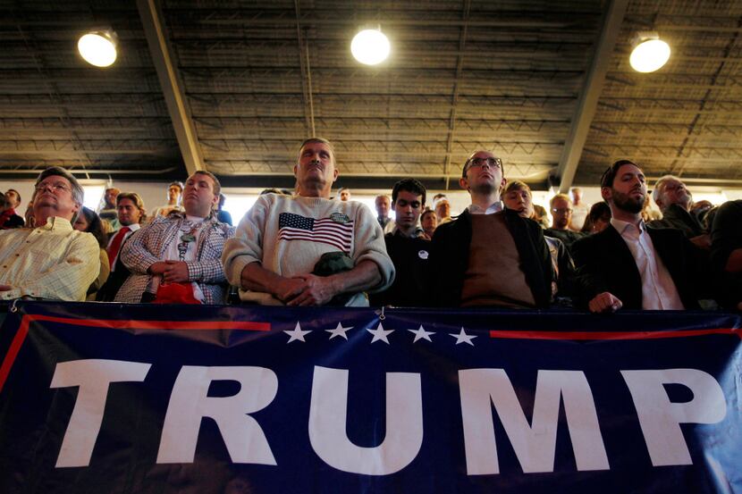 People pause in prayer during a campaign rally for Republican presidential candidate Donald...