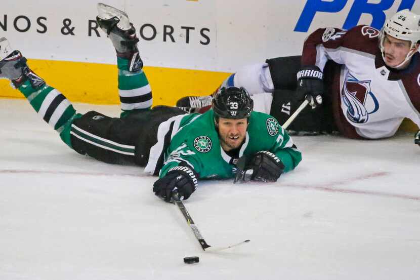 Dallas Stars defenseman Marc Methot (33) reaches for the puck near the boards during the...
