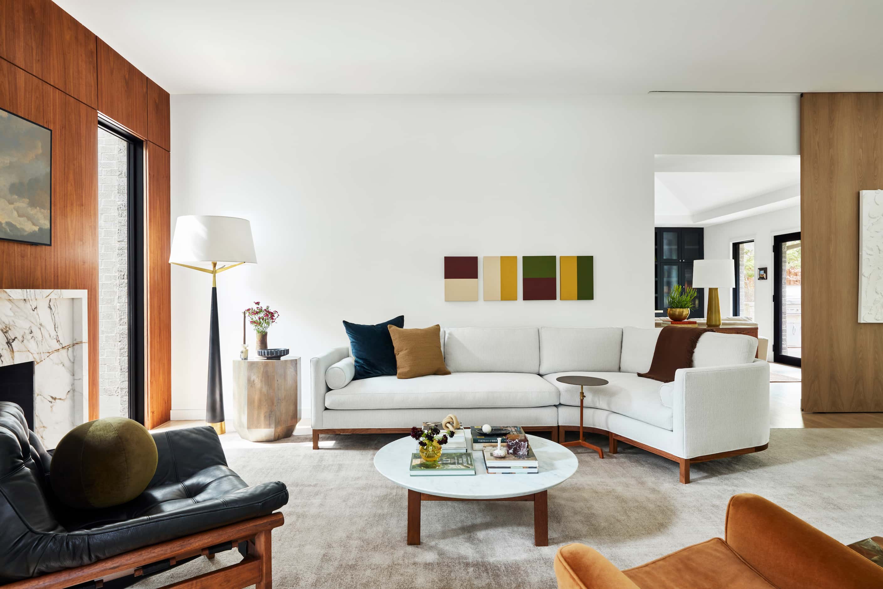 Living room with natural light, neutral-colored sectional sofa and contemporary artwork on...