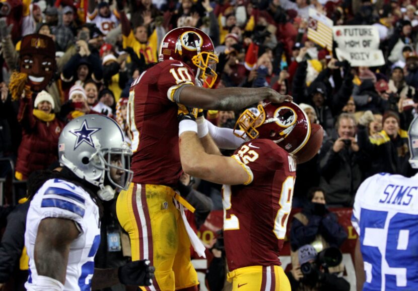 Washington Redskins quarterback Robert Griffin III (10) celebrates with teammate Washington...