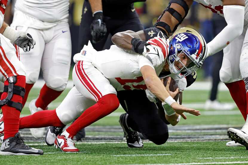 New York Giants quarterback Tommy DeVito (15) is sack day New Orleans Saints defensive end...