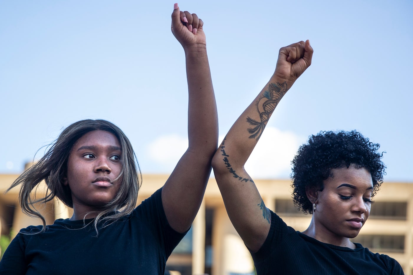 Tyra Wilson and Kita Williams participate in an 8-minute and 46-second kneel in honor of...