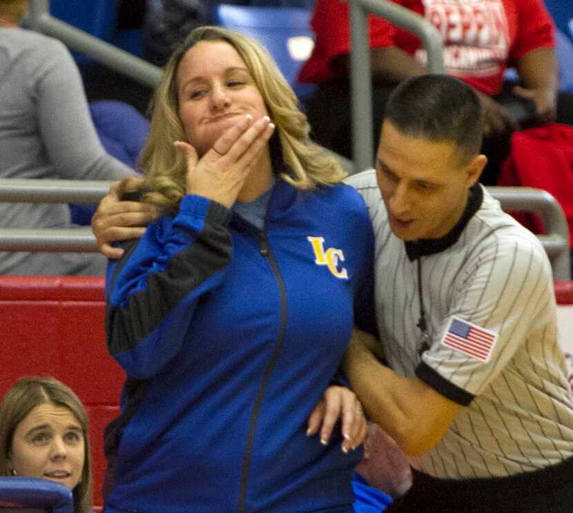 Garland Lakeview Centennial head coach Laura Holmes reacts after a collision with a referee...