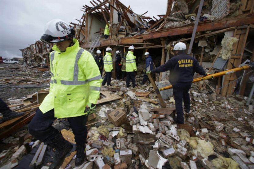 In this April 18, 2013 file photo, firefighters conduct a search and rescue of an apartment...