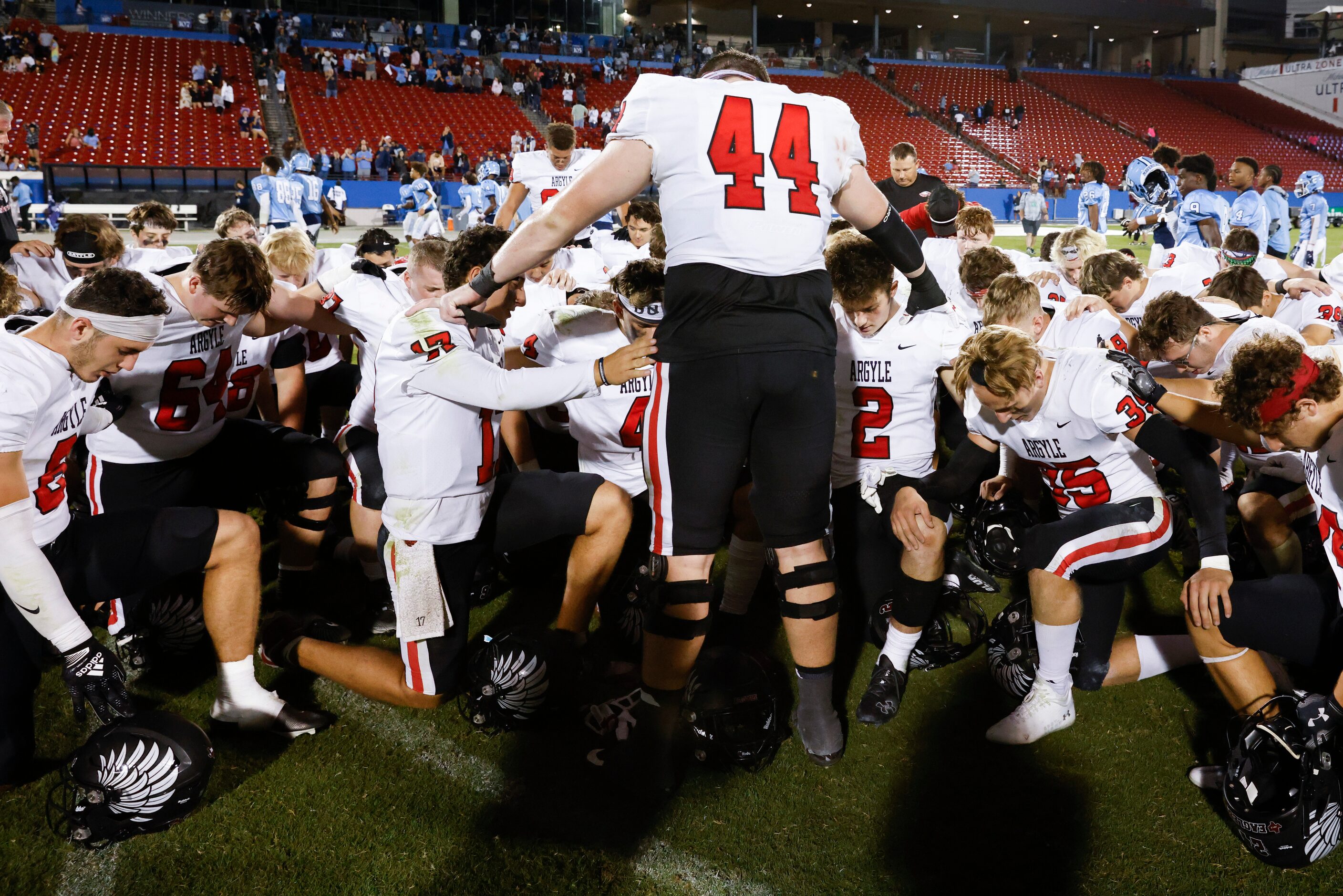 Argyle high players pray after winning against Emerson during a football game at Toyota...