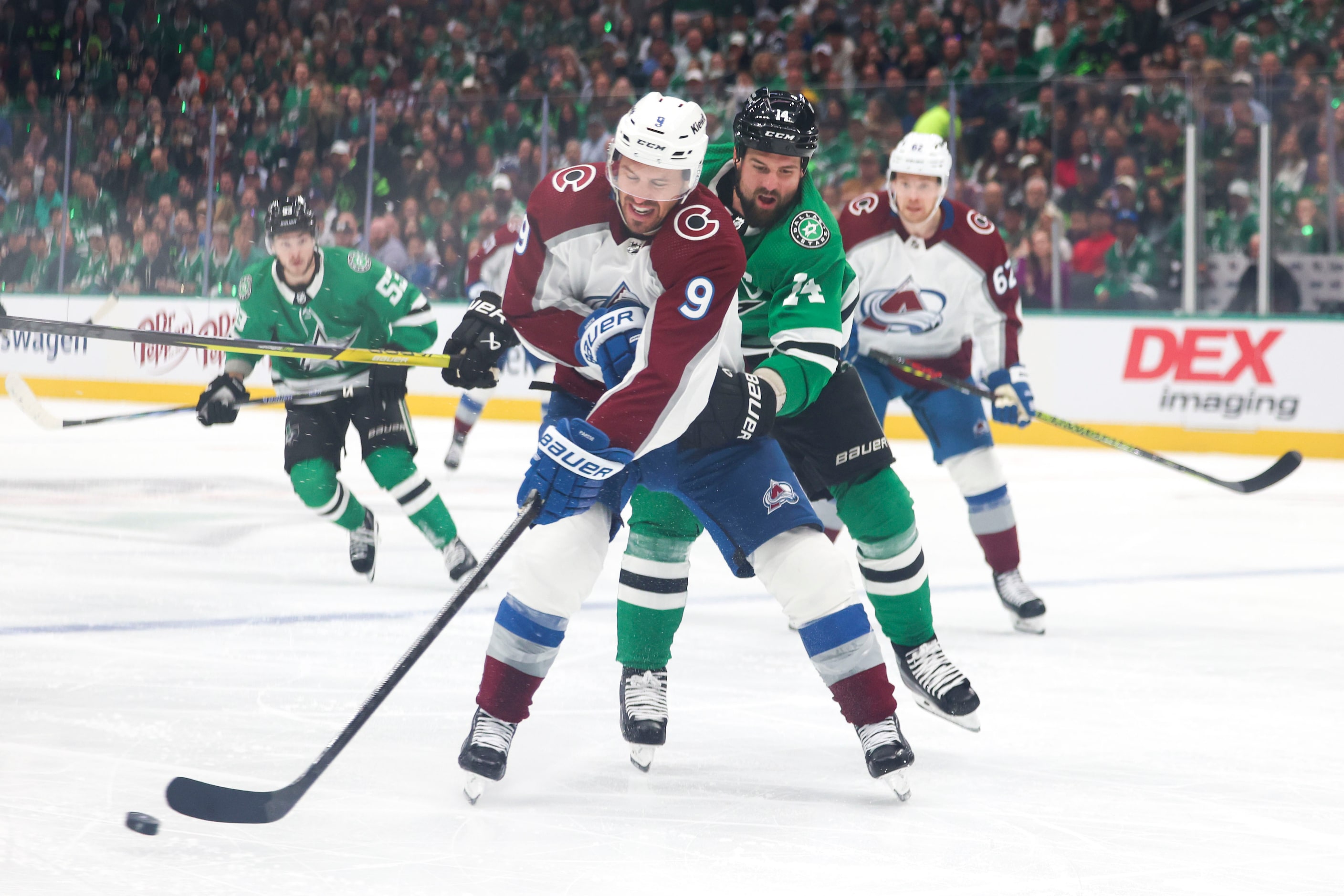 Colorado Avalanche left wing Zach Parise (front) defends the puck against Dallas Stars left...