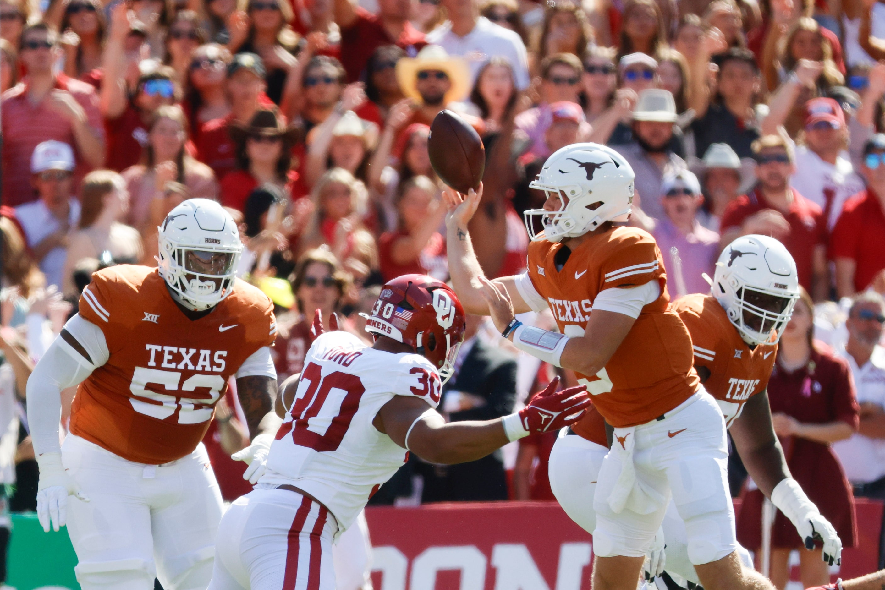 Texas quarterback Quinn Ewers (right) throws the ball against Oklahoma during the first half...