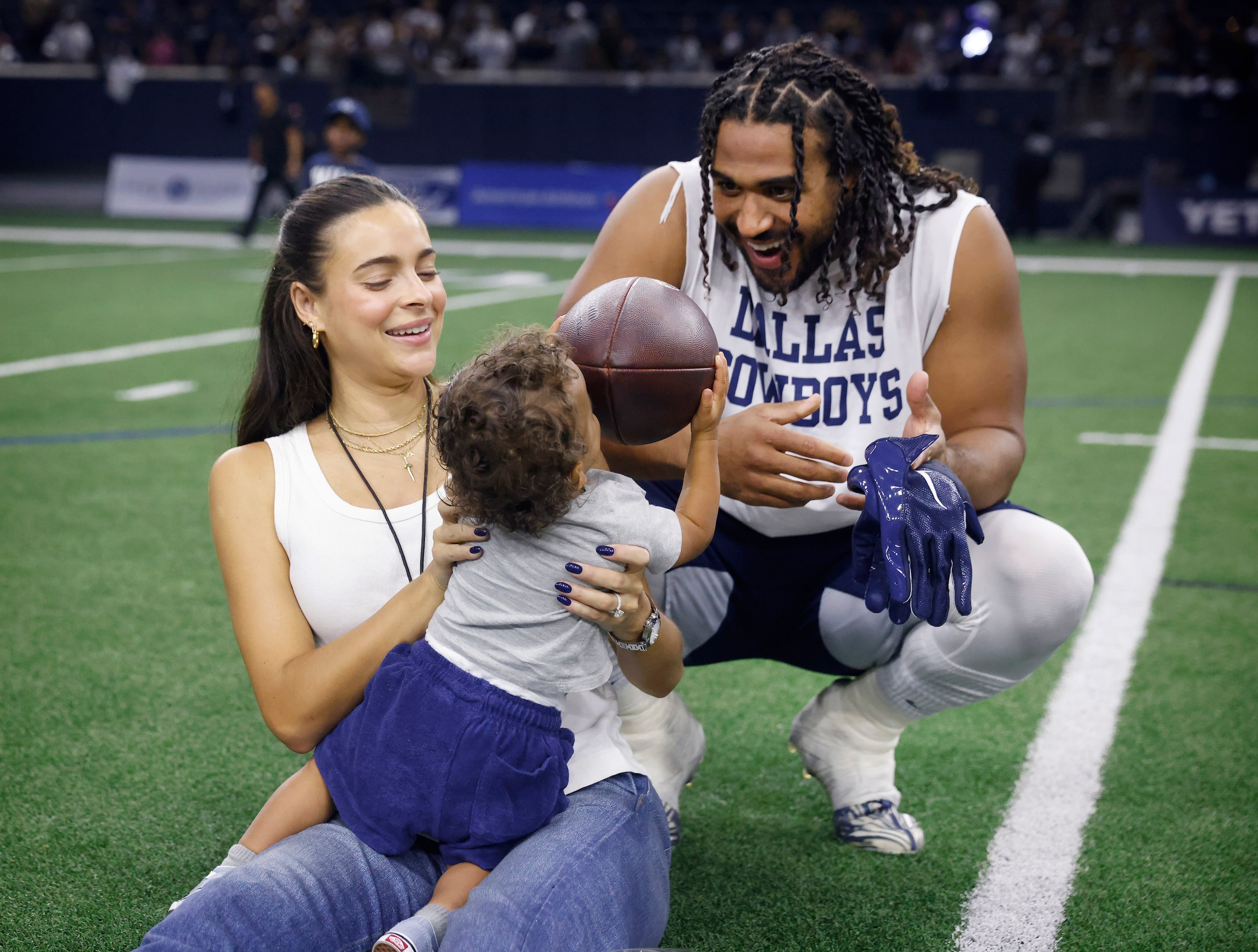 Dallas Cowboys linebacker Eric Kendricks, his wife Ally and son Knight play with a football...