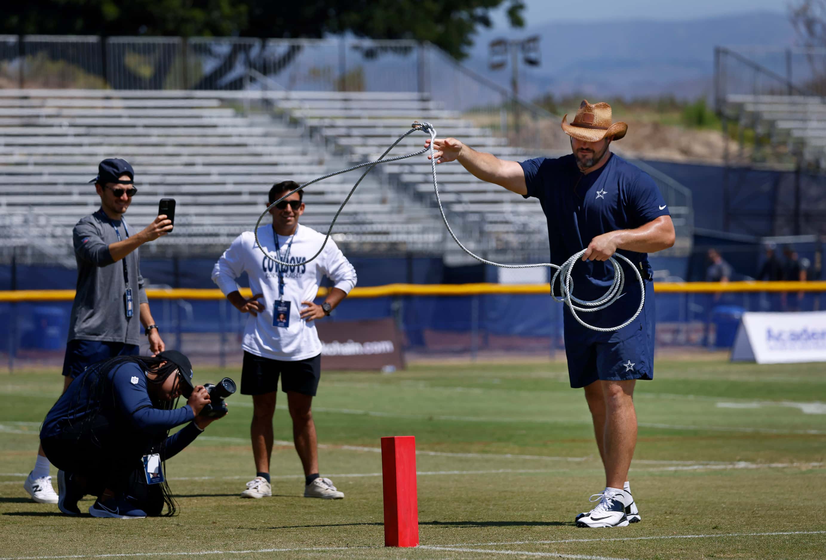 Donning a cowboy hat, Dallas Cowboys guard Zack Martin attempts to lasso a touchdown pylon...