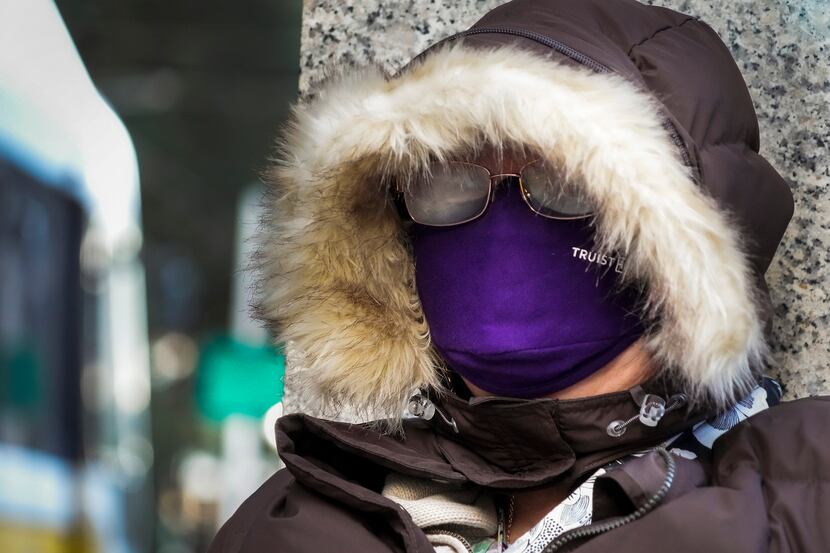Lianne Gasser bundles up against temperatures in the 30s as she wait on a train at the DART...