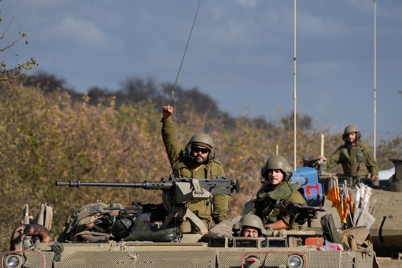 An Israeli soldier raises his fist from a moving APC in northern Israel near the...