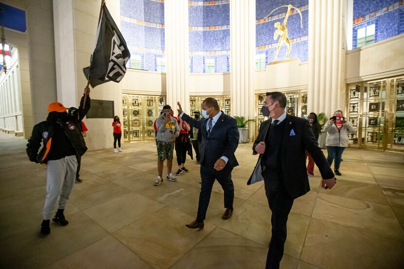 Dallas Mayor Eric Johnson waved to demonstrators with Next Generation Action Network as he...