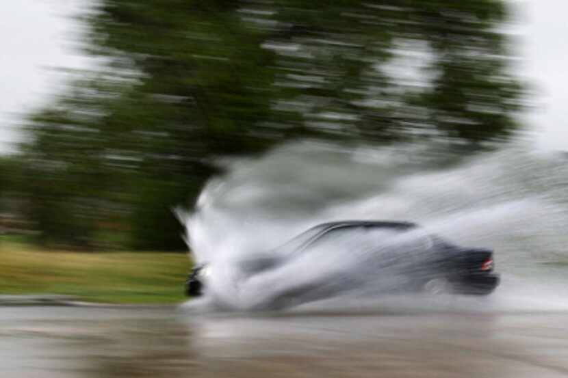 A car plowed through standing water on West Green Oaks Boulevard in Arlington after...