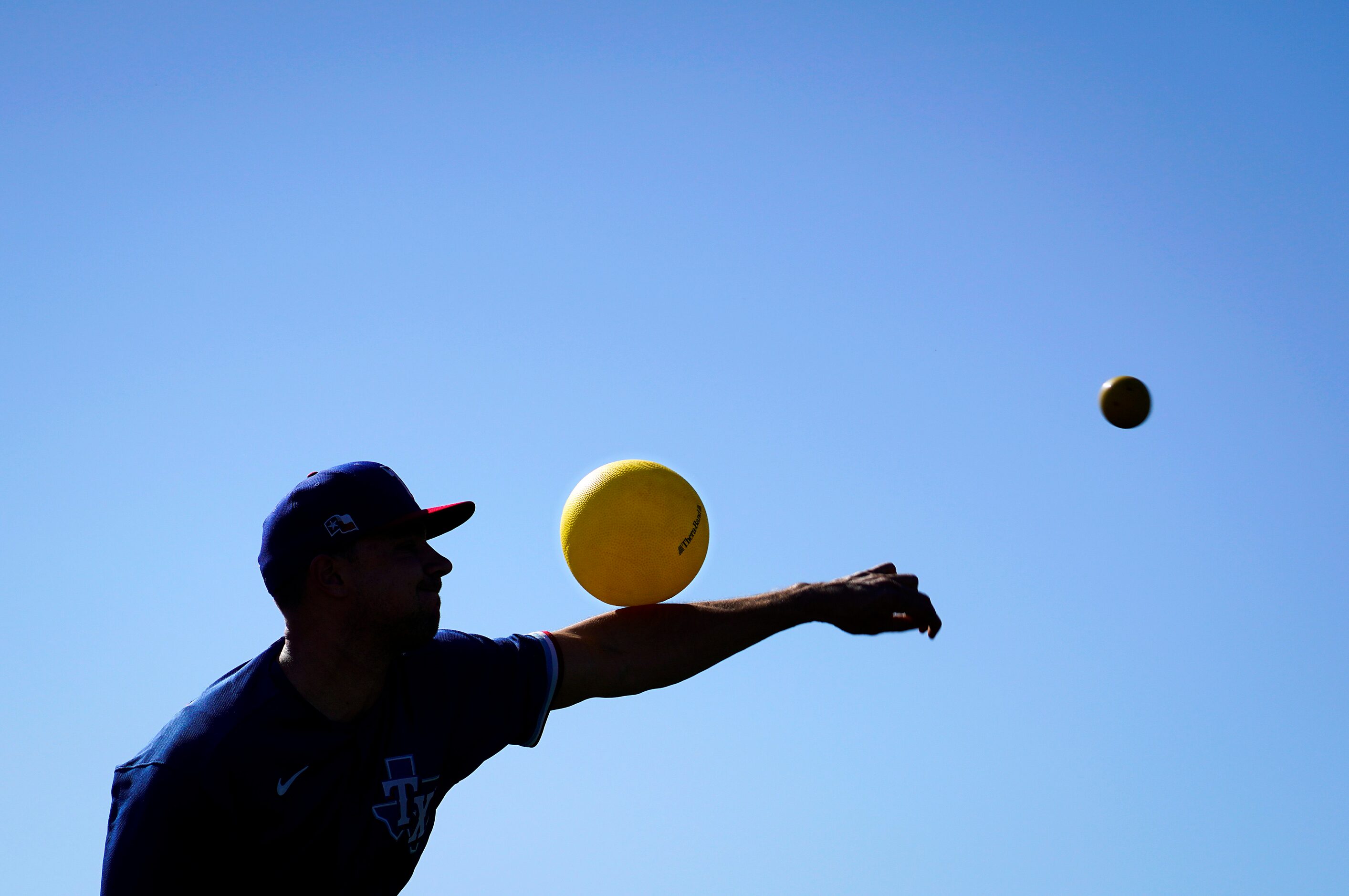 Texas Rangers pitcher Brock Burke  works with a heavy ball and inflatable ball in the...