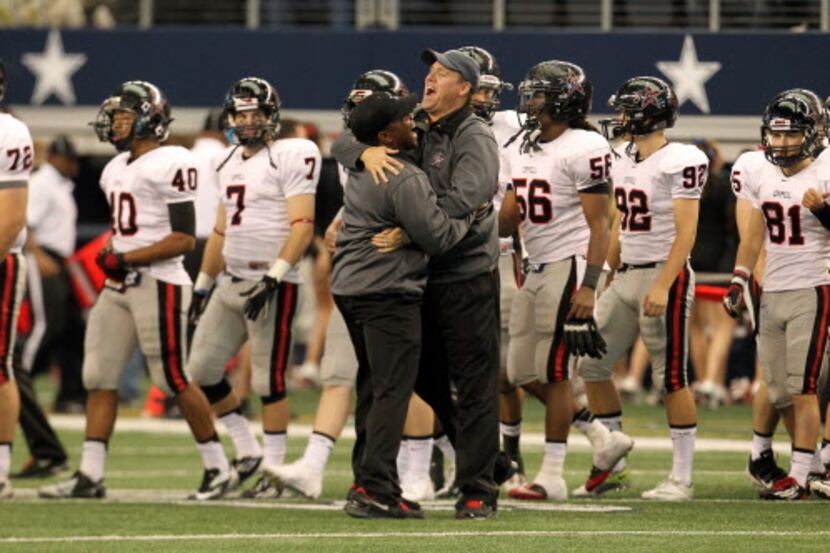 Coppell Head Coach Joe McBride, right, gets a hug from an assistant following a 31-7 win...