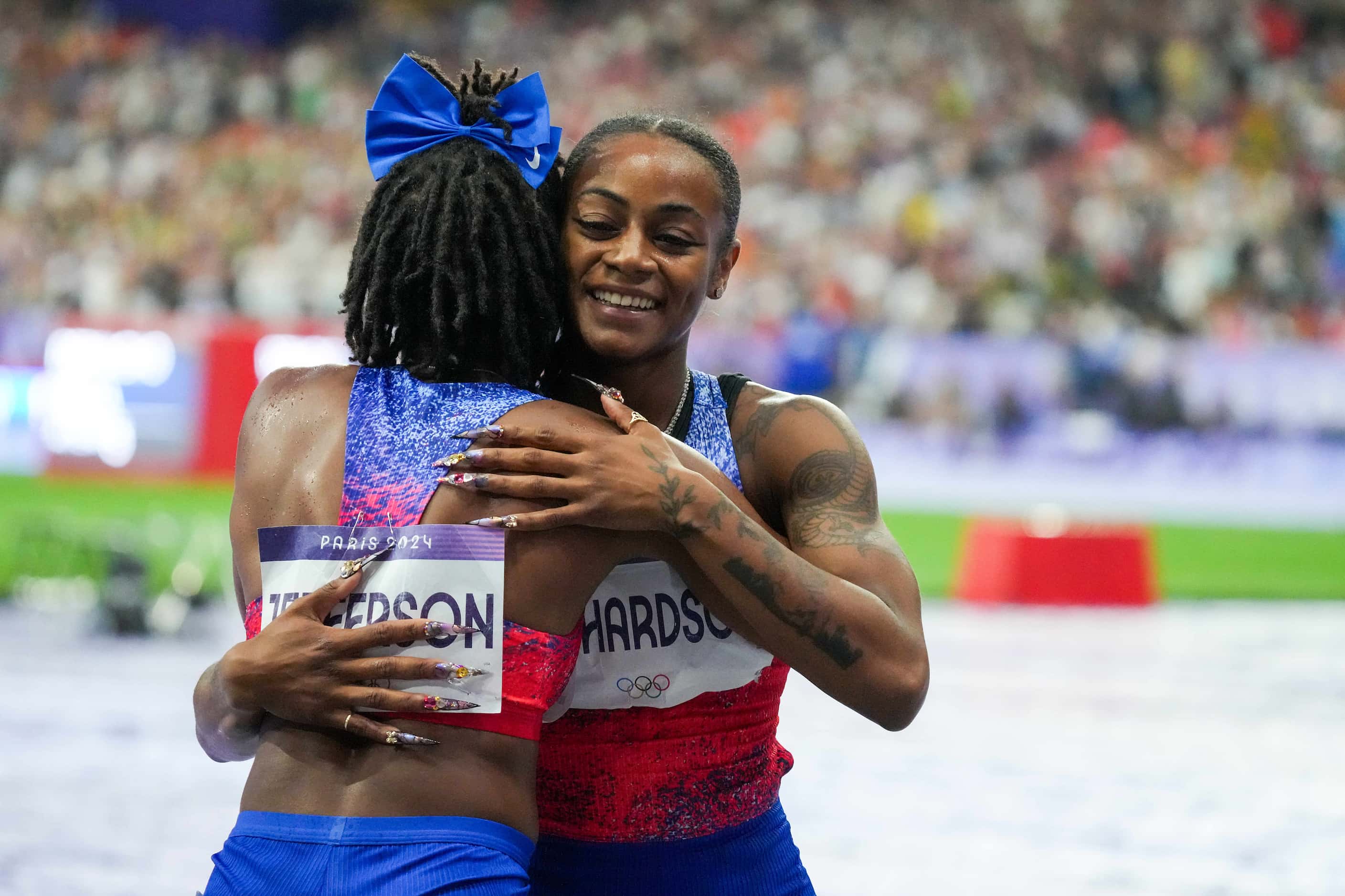 Silver medalist Sha'carri Richardson of the United States hugs bronze medalist teammate...