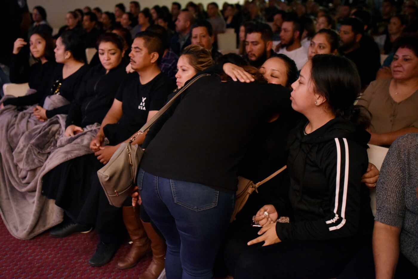A mourner hugs Raul Ortega Cabrera's widow during the viewing.