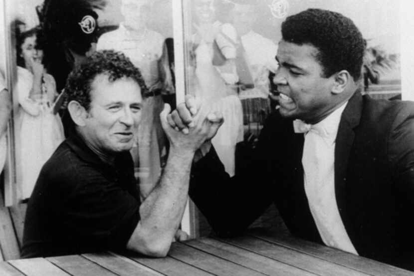 Novelist Norman Mailer is shown arm wrestling with heavyweight champion Muhammad Ali on the...