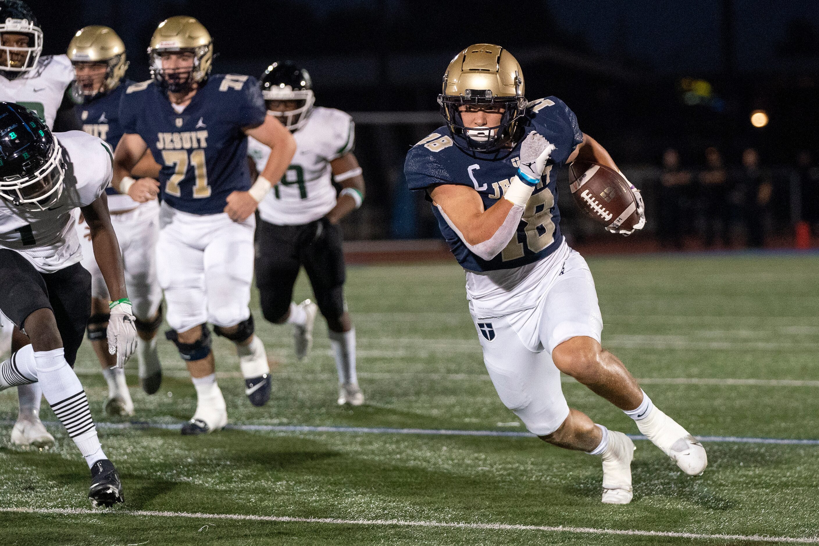 Jesuit senior running back Robert Fitzgerald (18) turns upfield during the first half of a...