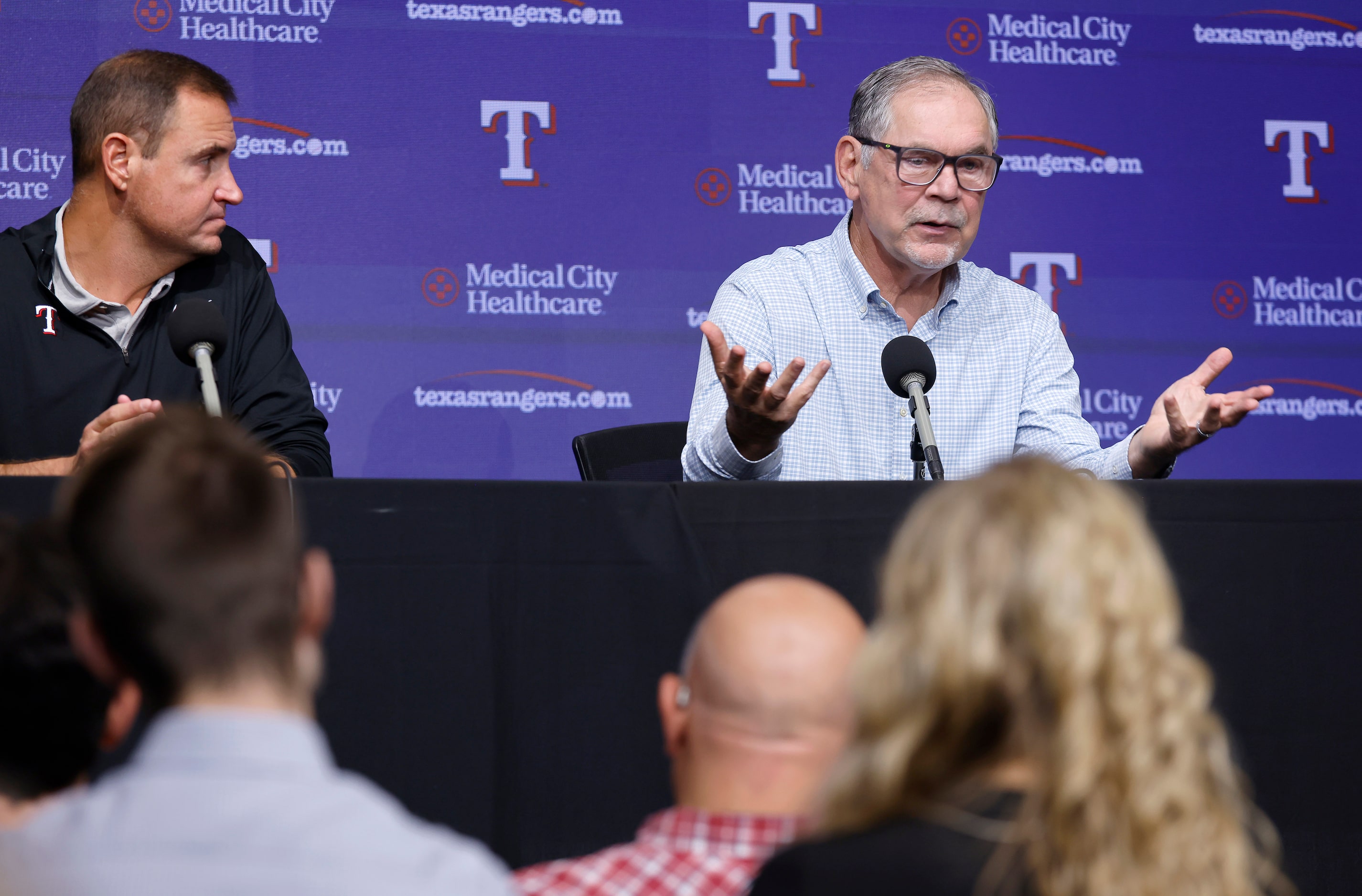 Alongside general manager Chris Young (left), Texas Rangers manager Bruce Bochy responds to...