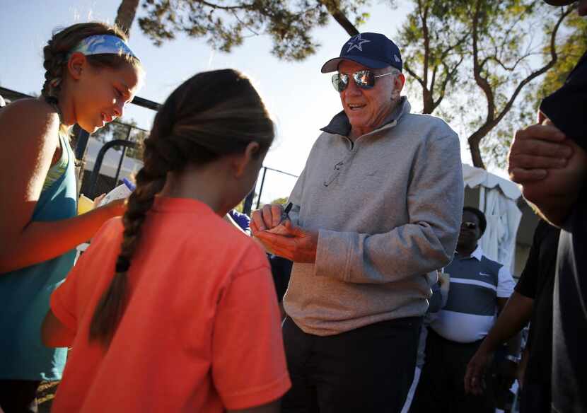 Dallas Cowboys owner Jerry Jones signs autographs for young fans following afternoon...