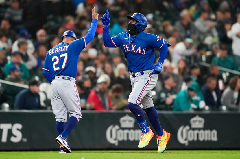 Texas Rangers' Adolis García, right, celebrates his solo home run against the Seattle...