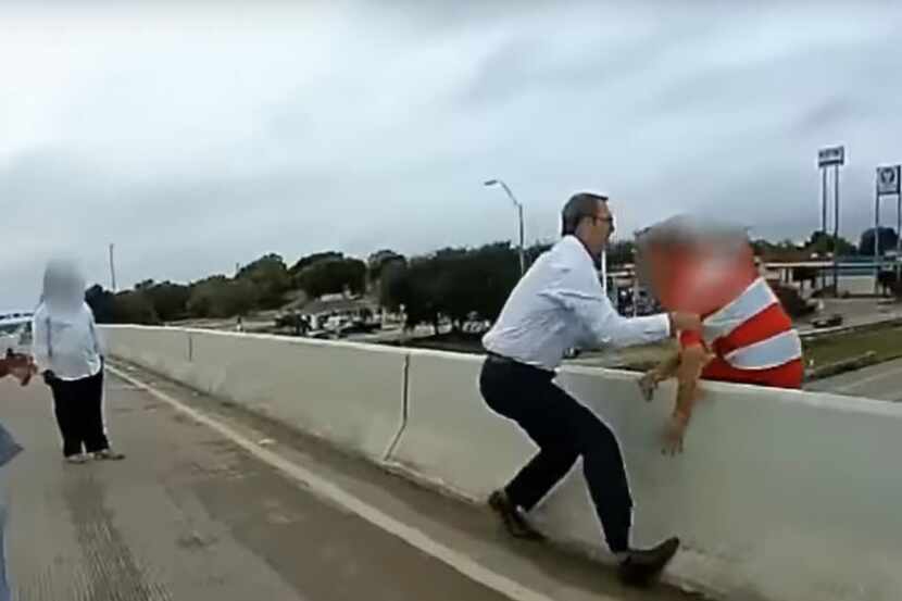Off-duty Red Oak police Officer Greg Dansby grabs a man just as he attempts to jump from the...