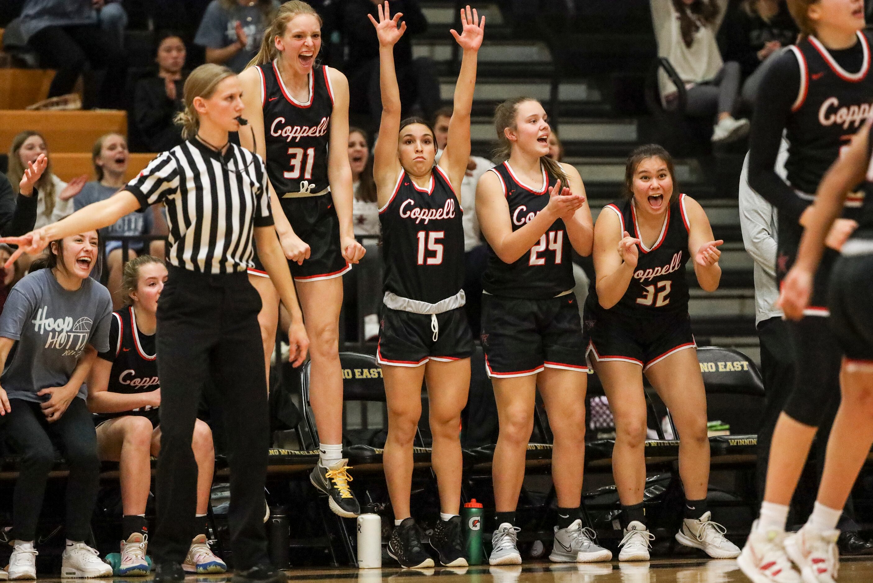 The Coppell High School woman’s basketball team bench reacts to the team scoring in the...