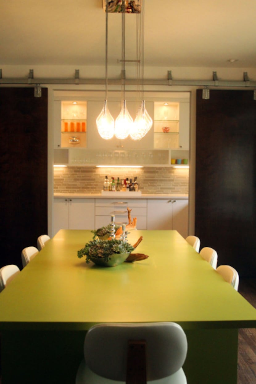 Dallas designer Katie Wietjes envisioned the custom lime-green dining table. Sliding panels...