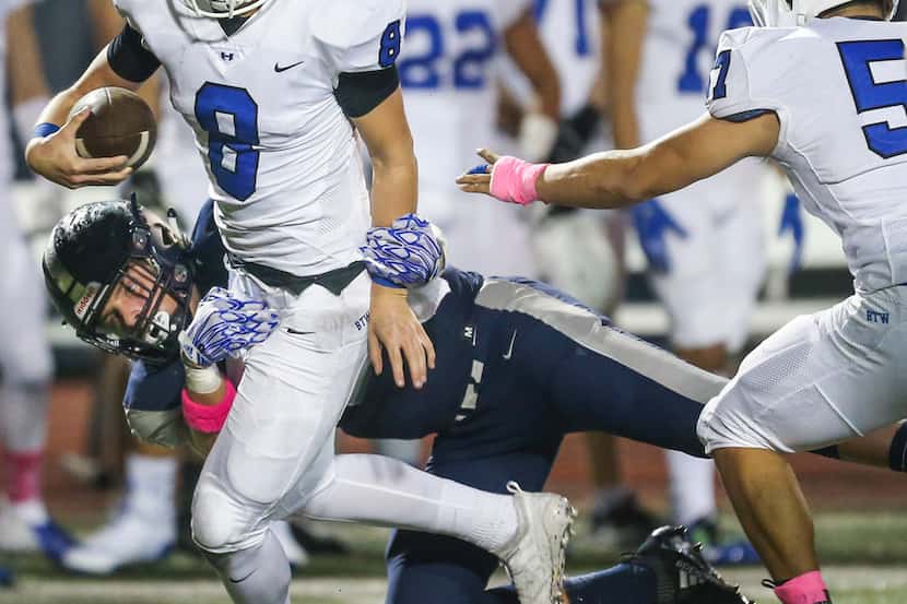 Hebron quarterback Carson Harris (8) is brought down by Flower Mound defensive end Stone Eby...