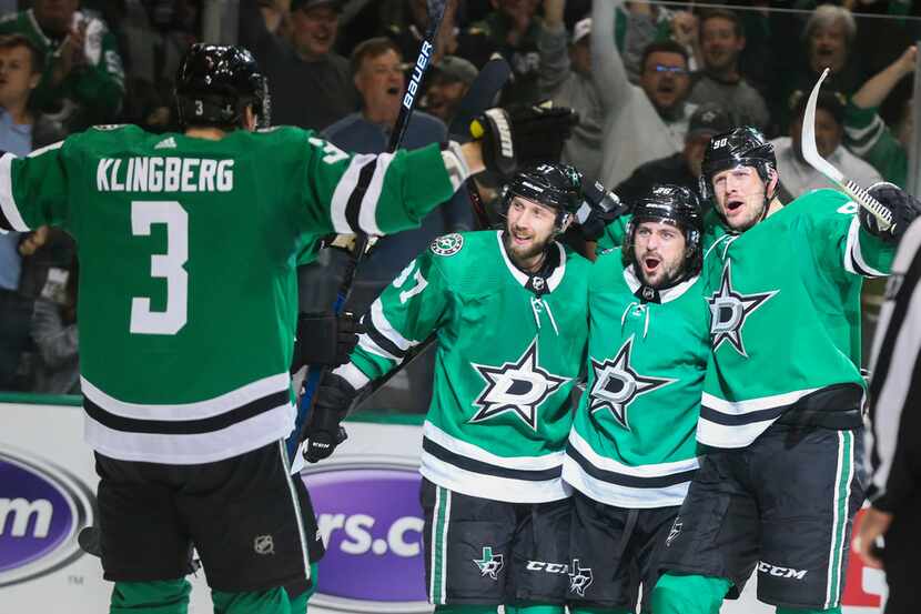 Dallas Stars defenseman John Klingberg (3) skates in to celebrate with center Justin Dowling...