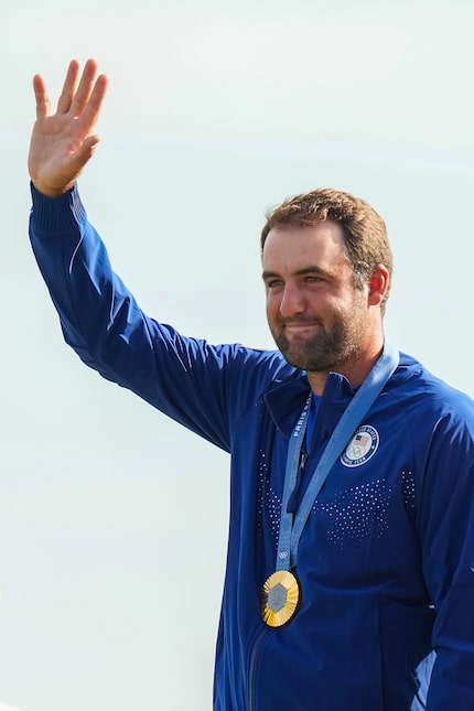 Gold medalist Scottie Scheffler of the United States waves on the awards stand during the...