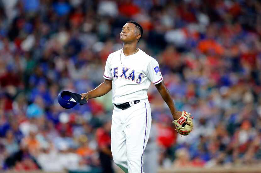 Texas Rangers relief pitcher Jose Leclerc (62) walks to the dugout after being pulled in the...