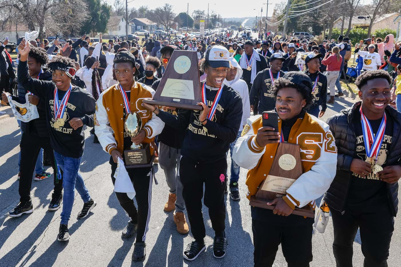 The South Oak Cliff team walks with the state championship trophy during a parade...