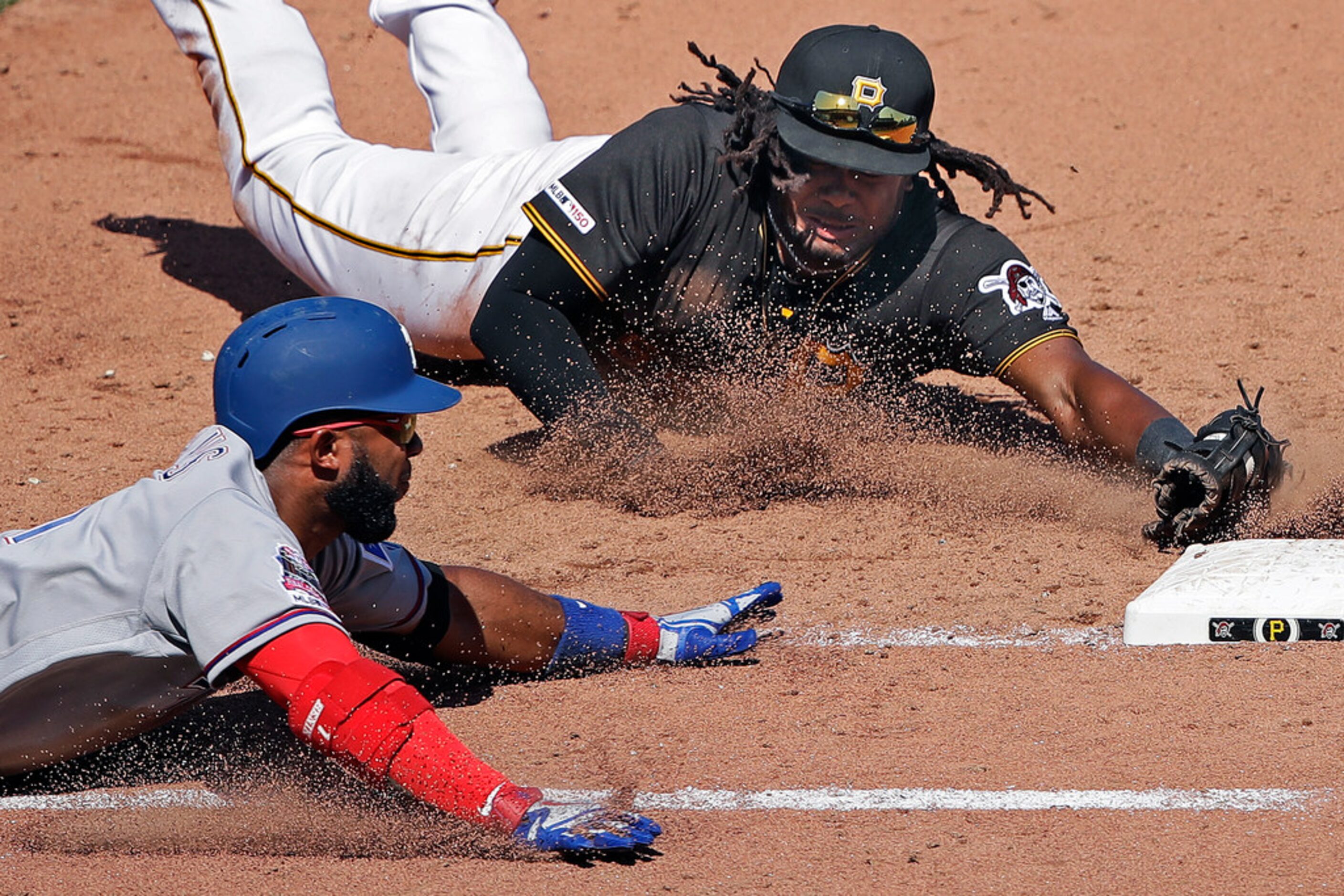 After fielding a bunt by Texas Rangers' Elvis Andrus, left, Pittsburgh Pirates first baseman...