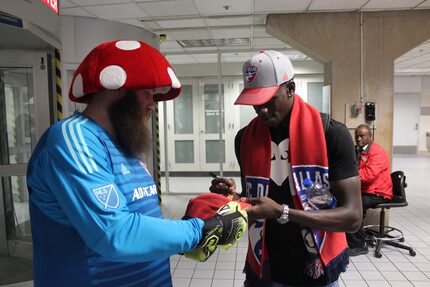 New FC Dallas striker Dominique Badji signs an autograph for FC Dallas fan Rob...