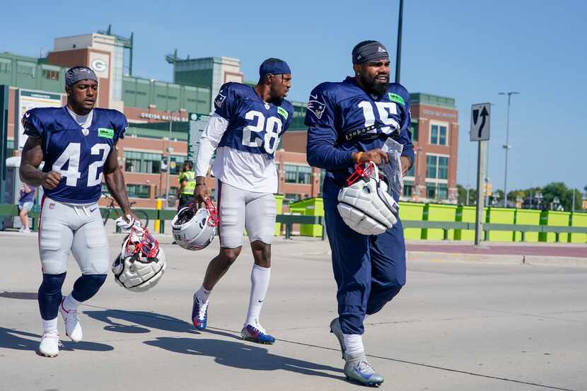 New England Patriots' Ezekiel Elliott along with J.J. Taylor (42) and Ameer Speed (28) walk...