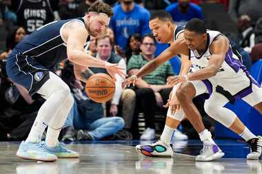 Dallas Mavericks guard Luka Doncic (77) and forward Grant Williams (3) try to steal the ball...