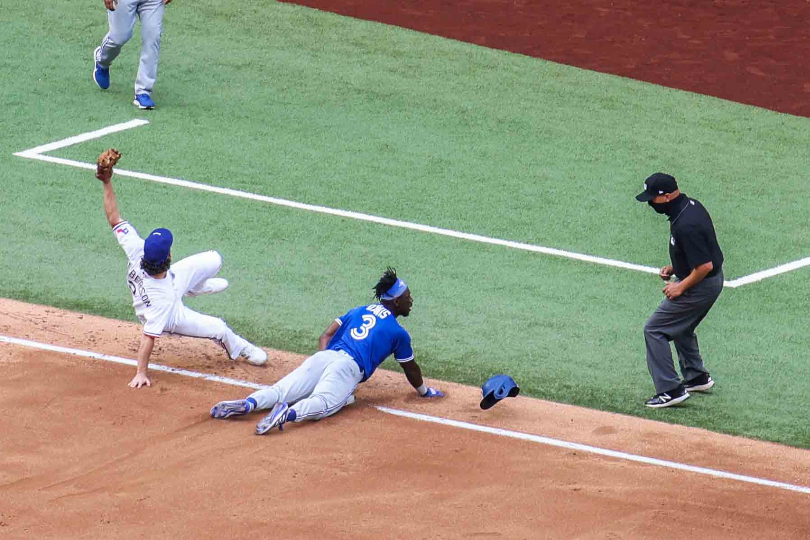 Toronto Blue Jays outfielder Jonathan Davis No. 3 gets tagged out by Texas Ranger infielder...