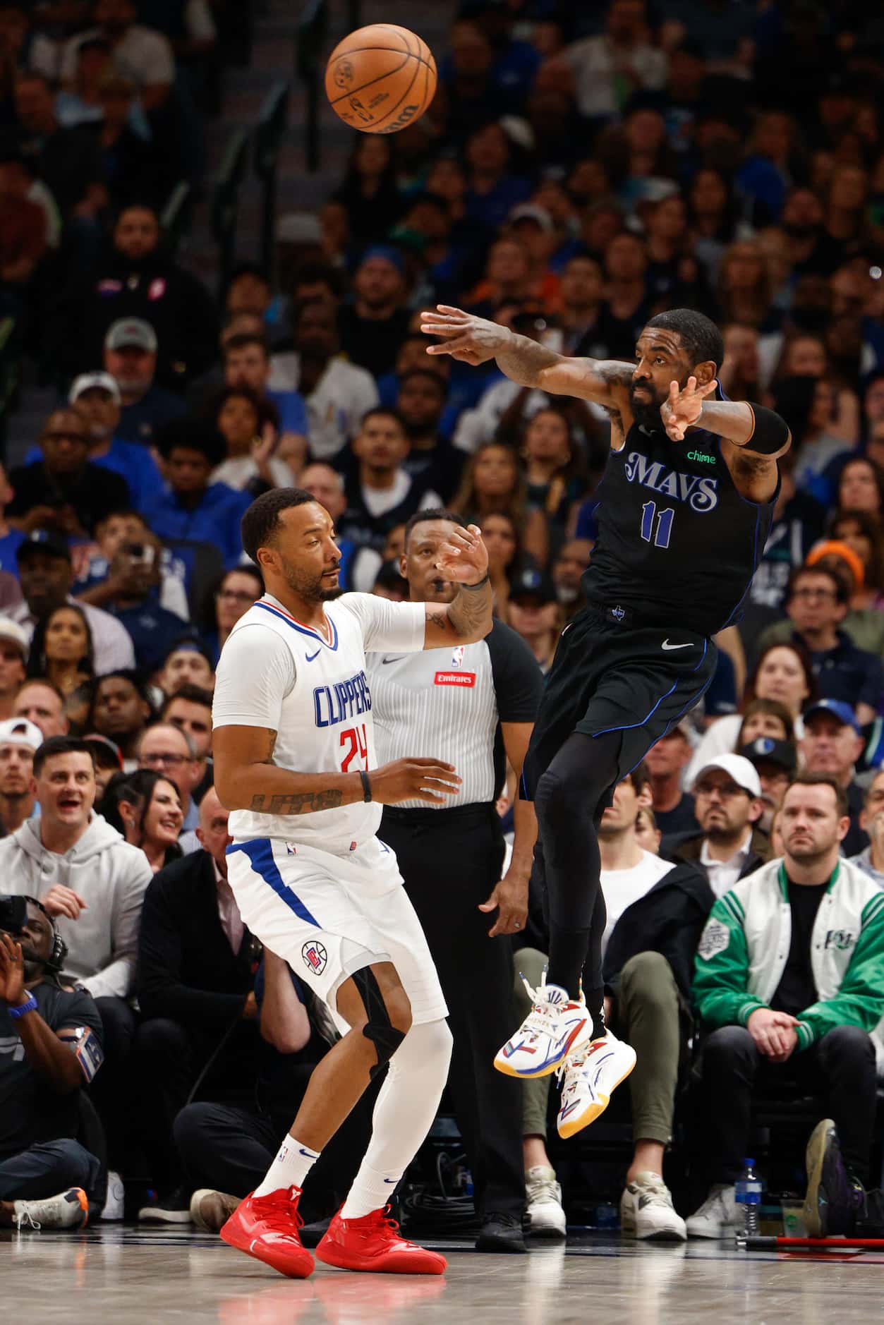 Dallas Mavericks guard Kyrie Irving (11) passes the ball over LA Clippers guard Norman...