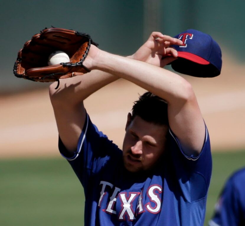 Texas Rangers starting pitcher Nick Tepesch wipes his face as he is taken out of the game...