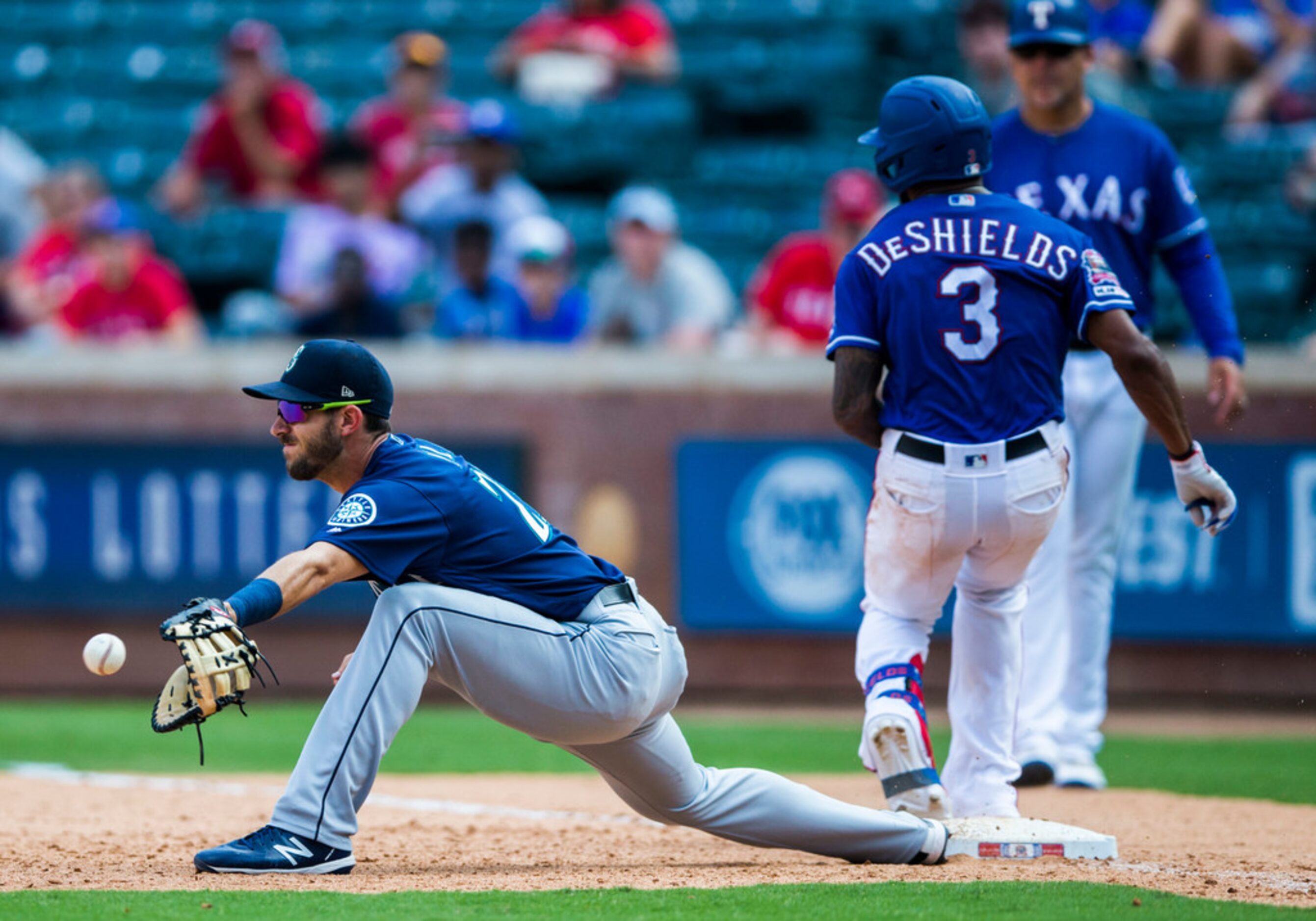 Texas Rangers center fielder Delino DeShields (3) makes it safely to first base ahead of a...