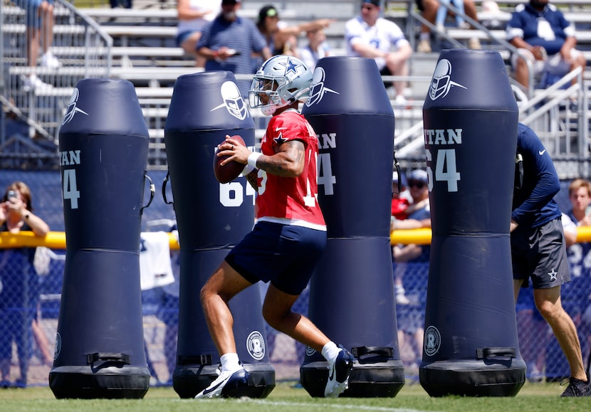 Dallas Cowboys quarterback Trey Lance (19) slides in and around blocking dummies as he...