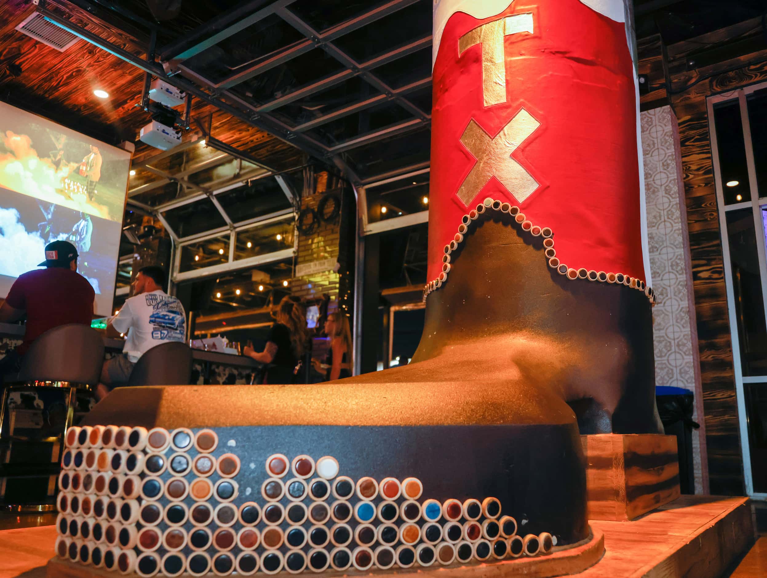 A giant boot sits by the bar at Koe Wetzel's Riot Room in Fort Worth on Thursday, March 23,...