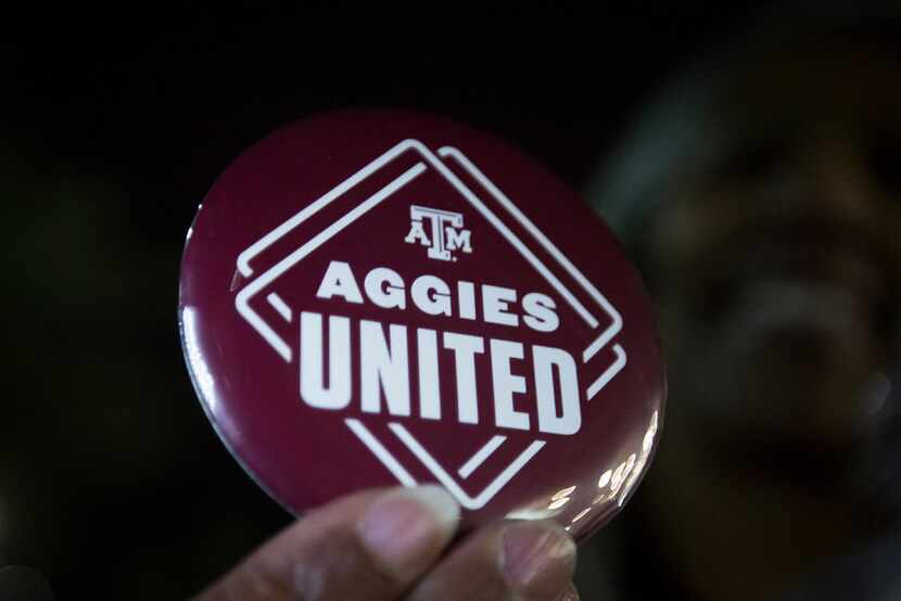 A woman shows off a button during the Aggies United event at Kyle Field on the campus of...