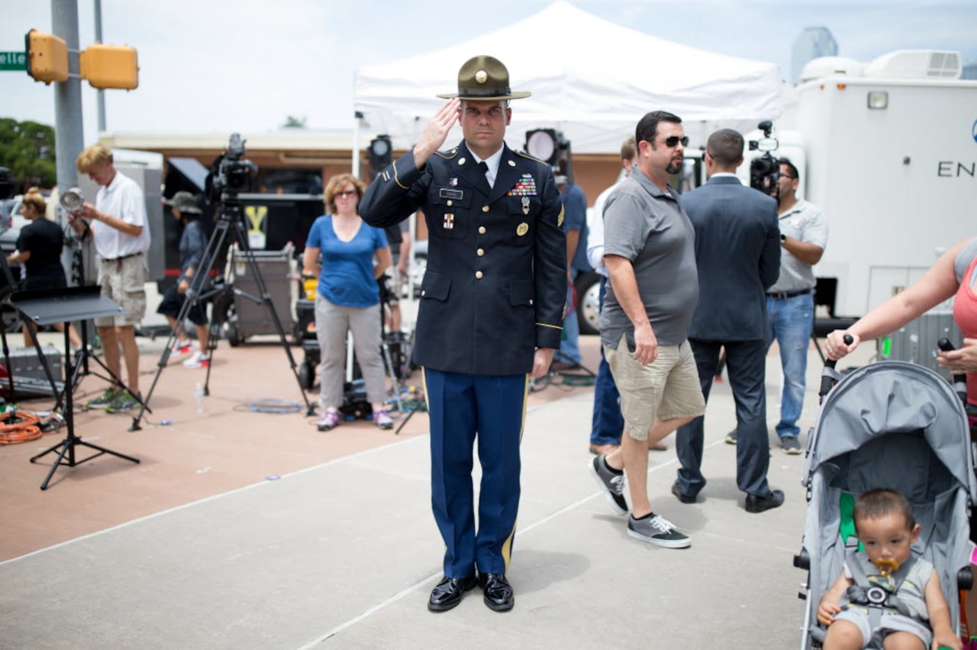 Retired Army combat medic Chandler Davis stood saluting the memorial for the slain officers...