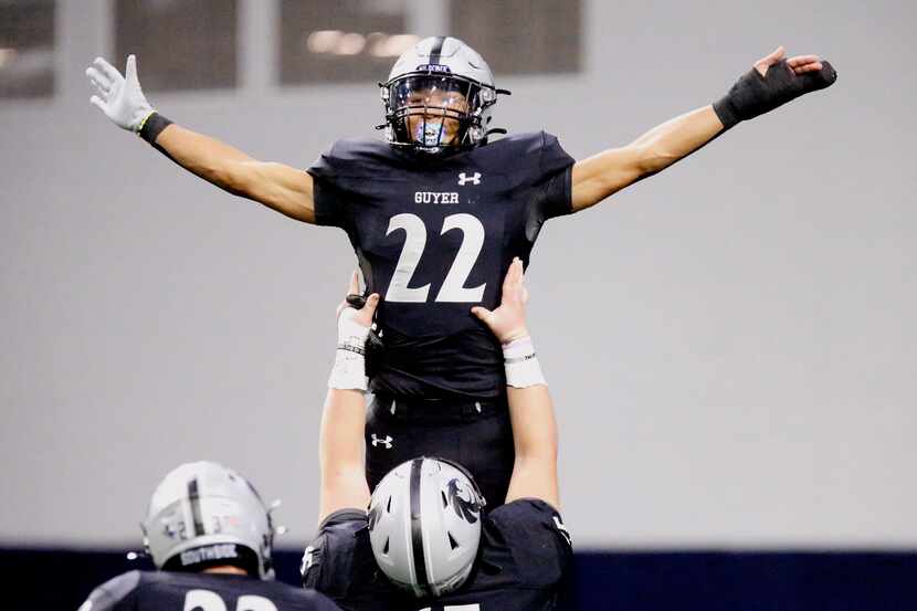 Guyer High School punt returner Peyton Bowen (22) is hoisted up by Guyer High School’s Kaleb...