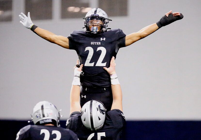 Guyer High School punt returner Peyton Bowen (22) is hoisted up by Guyer High School’s Kaleb...